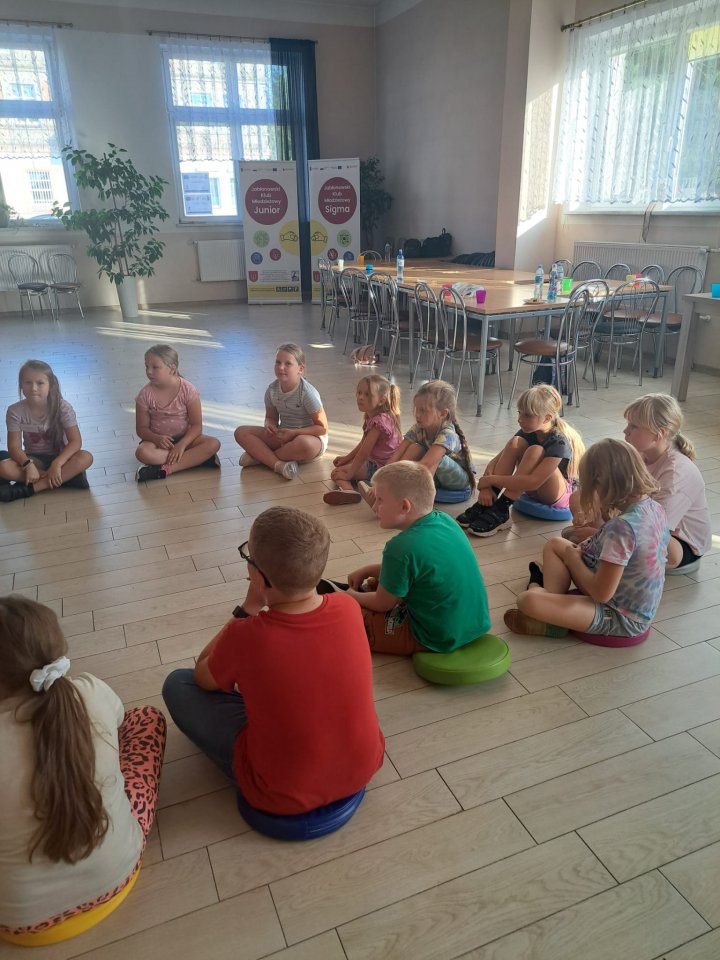 dzieci siedzą w kółku.