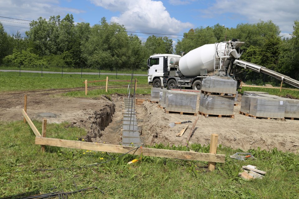 Zdjęcie Na zdjęciu ciężki sprzęt i bloki betonowe.