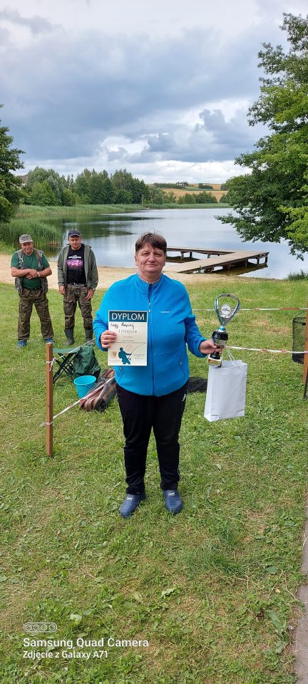 Zawody wędkarskie Uczestniczka zawodów z nagrodami w ręku.