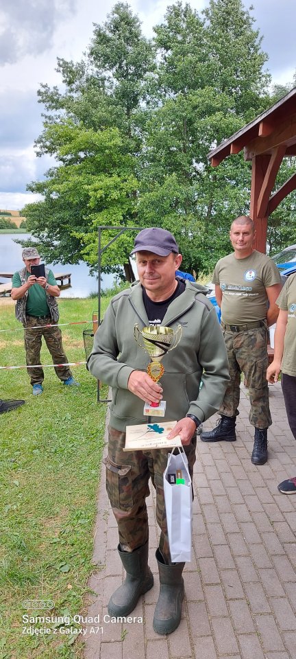 Zawody wędkarskie zawodnik z nagrodą i pucharem