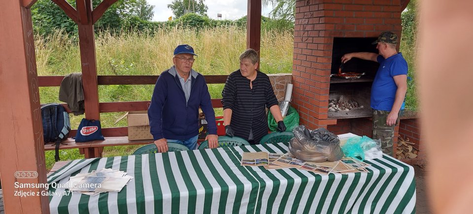 Zawody wędkarskie Dwóch wędkarzy siedzi pod wiatą na plaży.