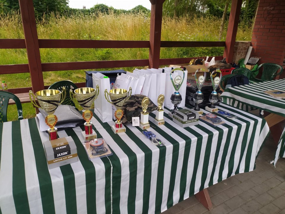 Zawody wędkarskie Nagrody puchary, torby na stole.